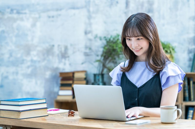 シックな部屋でノートパソコンを使う女性